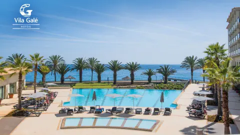 Pool mit Blick auf Palmen und Meer im Hotel Vila Galé Santa Cruz-placeholder